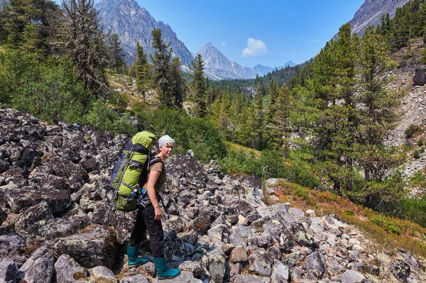 Woman researcher wildlife with a heavy backpack — Stock Photo, Image