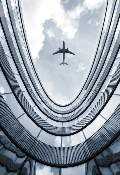 Edificio moderno con avión volador — Foto de Stock