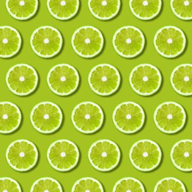 Yeşil arka planda yeşil limon dilimleri olan canlı bir arka plan. En az düz besin kalıbı ve dokusu 