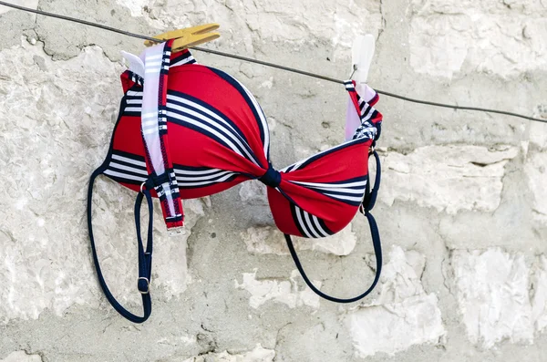 Red swimsuit on clothesline — Stock Photo, Image