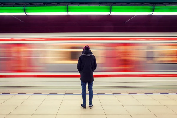 Подросток на станции метро и движущийся поезд — стоковое фото