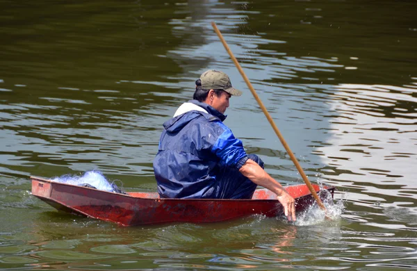 Pêcheur lance pêche dans un bateau sur le lac Ouest à Hanoi . — Photo