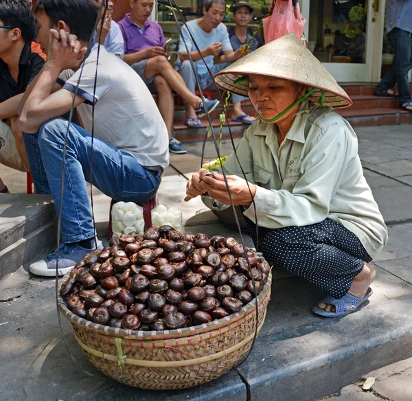 Žena, loupání kaštany v Hanoji — Stock fotografie