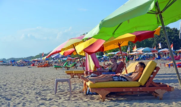 Туристи відкласти на стільці крісло на пляжі Легіан, Балі — стокове фото