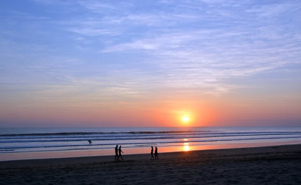 漫步在日落时分在勒吉安海滩，巴厘岛上的人 — 图库照片