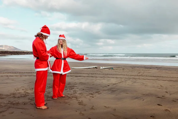 Et par kledd som julenissen på stranden. – stockfoto
