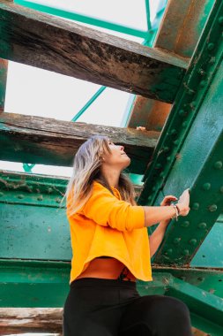 Kadın eski, terk edilmiş demir demiryolu köprüsünü keşfederken eğleniyor.