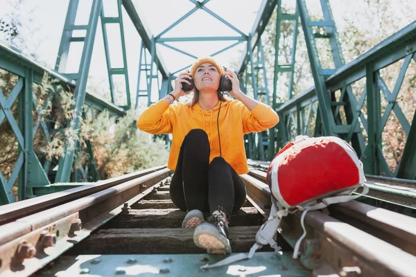 Frau Hört Musik Mit Kopfhörern Auf Verlassener Eisenbahnbrücke — Stockfoto