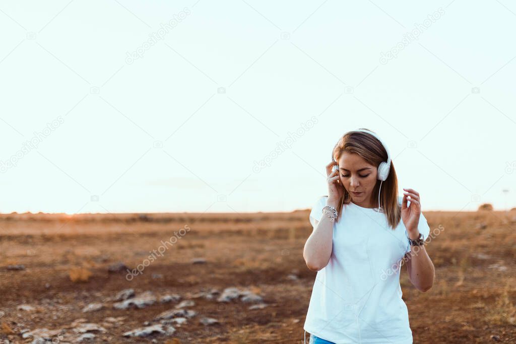 Young woman with her laptop listened external communications with headphones