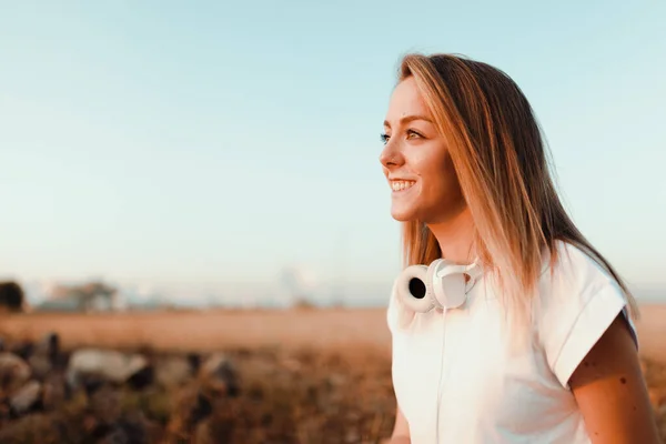 Giovane Donna Guardando Tramonto Con Cuffie Sul Campo — Foto Stock