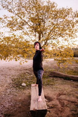 Yoga yapan ve park bankında uzanan bir kadın.