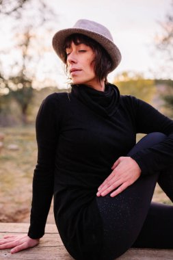 Yoga yapan ve park bankında uzanan bir kadın.