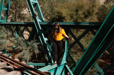 Yolları keşfeden bir kadın ve eski bir demir demiryolu köprüsü