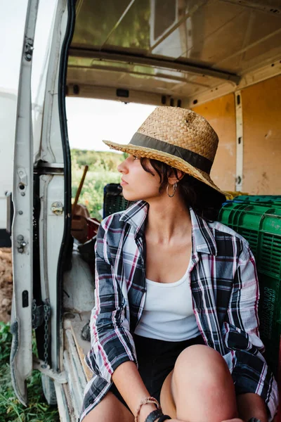 若い農家の女性が畑のバンで休んでいる — ストック写真