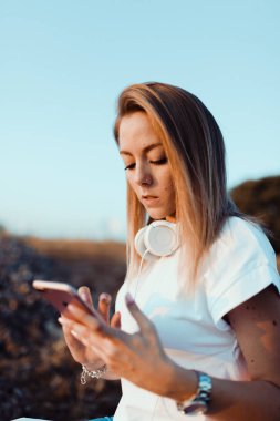 Genç bayan sahada akıllı telefonuna not aldı.