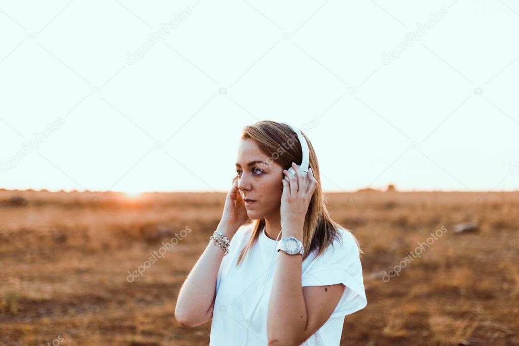 Young woman with her laptop listened external communications with headphones