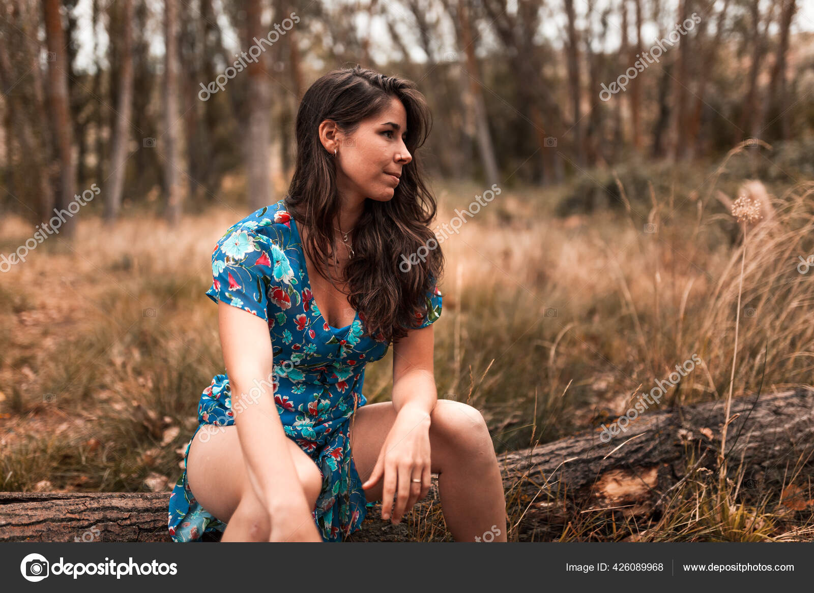 A 35 year old brunette woman in a forest wearing a small top