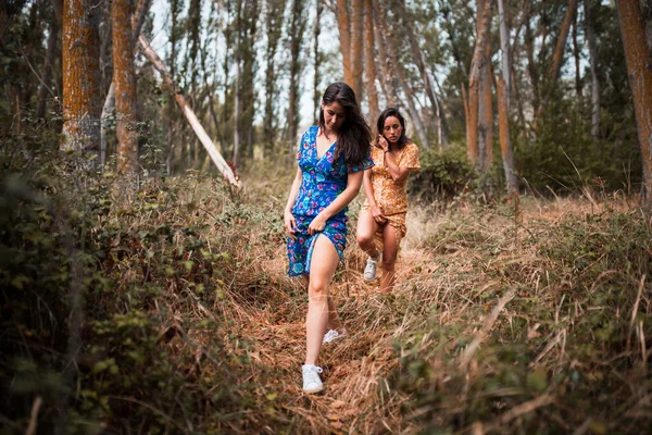 Duas Jovens Lésbicas Andando Mãos Dadas Floresta Usando Vestidos Longos — Fotografia de Stock