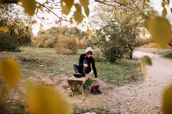 Kvinna vandrare vilar på bänken i parken efter vandring — Stockfoto