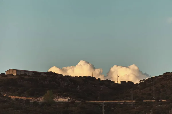 Sunset scene with clouds behind hills. — Stock Photo, Image