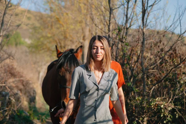 Zwei Freundinnen plaudern und reiten mit ihrem Pferd durch die Landschaft — Stockfoto