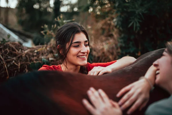 Duas mulheres amigas conversando e dando um passeio com seu cavalo pelo campo — Fotografia de Stock