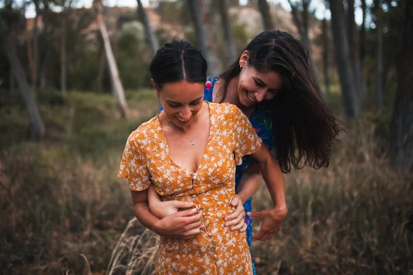 Un par de lesbianas caminando sobre un árbol caído — Foto de Stock