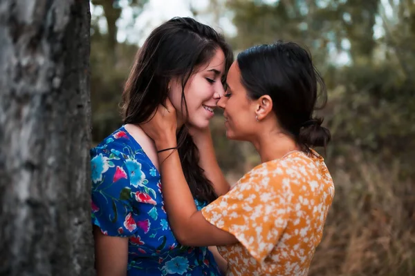 Twee jonge lesbiennes zoenen en strelen elkaar in het bos — Stockfoto