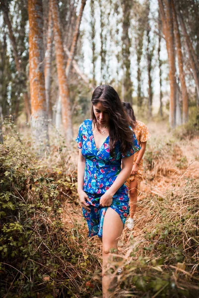 Uzun elbiseler içinde ormanda yürüyen iki genç lezbiyen. — Stok fotoğraf