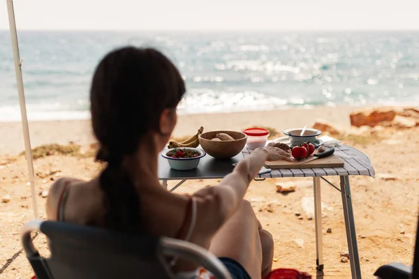 Una joven desayunando en su caravana observando una buena vista de la playa —  Fotos de Stock