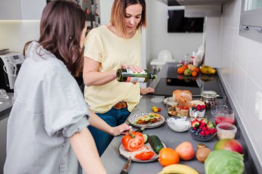 Kadınlar mutfakta sağlıklı yiyecekler hazırlıyor, eğleniyor, diyet yapıyor..