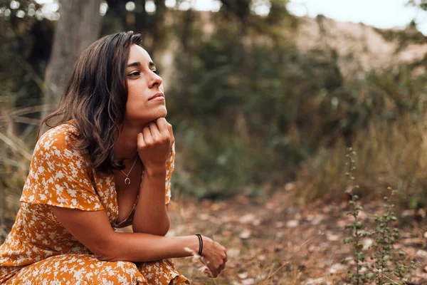 Ragionevole bella donna bruna indossa un vestito accovacciato nel bosco — Foto Stock