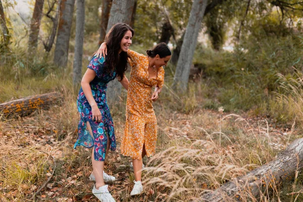 A couple of lesbians walking over a fallen tree — Stock Photo, Image