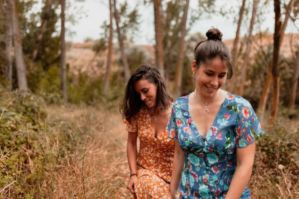 Deux jeunes lesbiennes marchant dans les bois portant de longues robes — Photo