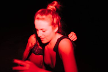 Bir grup genç kadın gece göldeki bir partide kırmızı ışıkta eğleniyorlar.