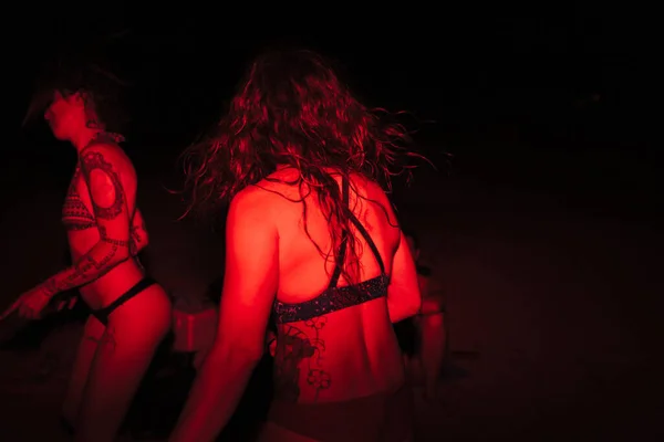 Grupo de jovens mulheres se divertindo em uma festa à beira do lago à noite com uma luz vermelha — Fotografia de Stock