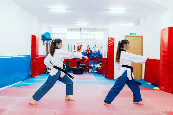 Two young women practice taekwondo in a training center — Stock Photo, Image