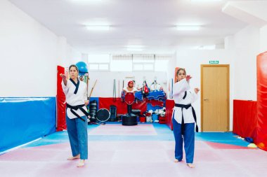 İki genç kadın bir eğitim merkezinde tekvando çalışıyor.