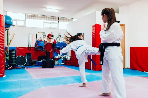 Two young women practice taekwondo in a training center — Stock Photo, Image