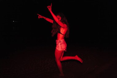 Bir grup genç kadın gece göldeki bir partide kırmızı ışıkta eğleniyorlar.