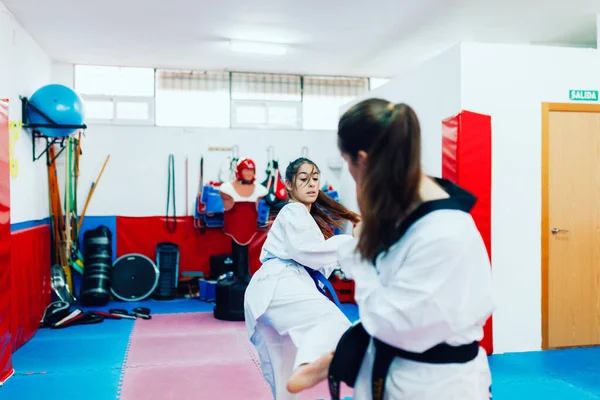 Two young women practice taekwondo in a training center — Stock Photo, Image