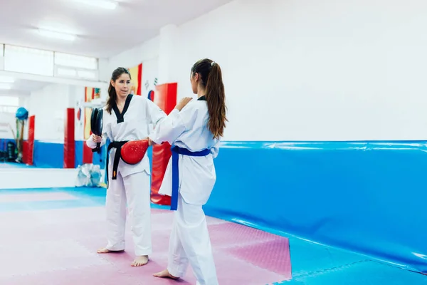 Two young women practice taekwondo in a training center — Stock Photo, Image