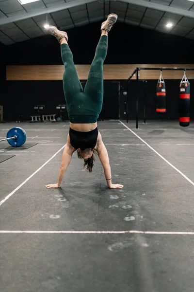 Молода жінка тренується на підлозі в тренажерному залі, що практикує тумбочку — стокове фото
