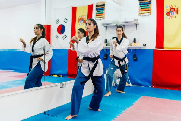 Dwie młode kobiety ćwiczą taekwondo w ośrodku treningowym — Zdjęcie stockowe