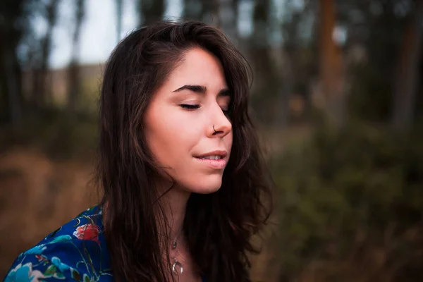 Retrato ao ar livre de uma bela mulher morena vestindo um vestido na floresta — Fotografia de Stock