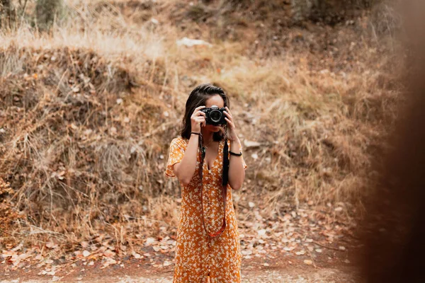 Ragazza fotografa nel bosco tiene in mano una vecchia macchina fotografica vintage — Foto Stock