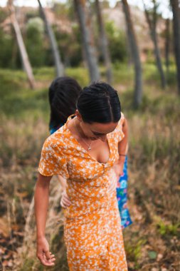 Bir çift lezbiyen devrilmiş bir ağacın üzerinde yürüyor.