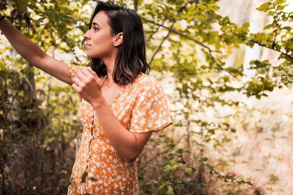 Utomhus porträtt av en vacker brunett kvinna bär en klänning i skogen — Stockfoto