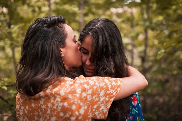 Twee jonge lesbiennes zoenen en strelen elkaar in het bos — Stockfoto