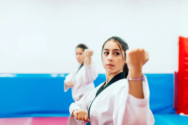 Two young women practice taekwondo in a training center — Stock Photo, Image
